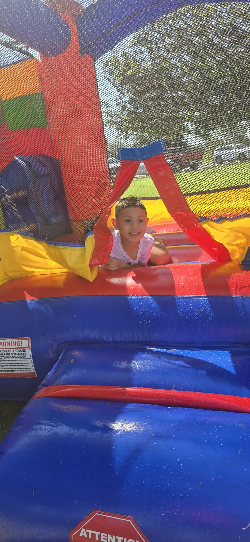 A camper enjoying the colorful inflatable during Water Day